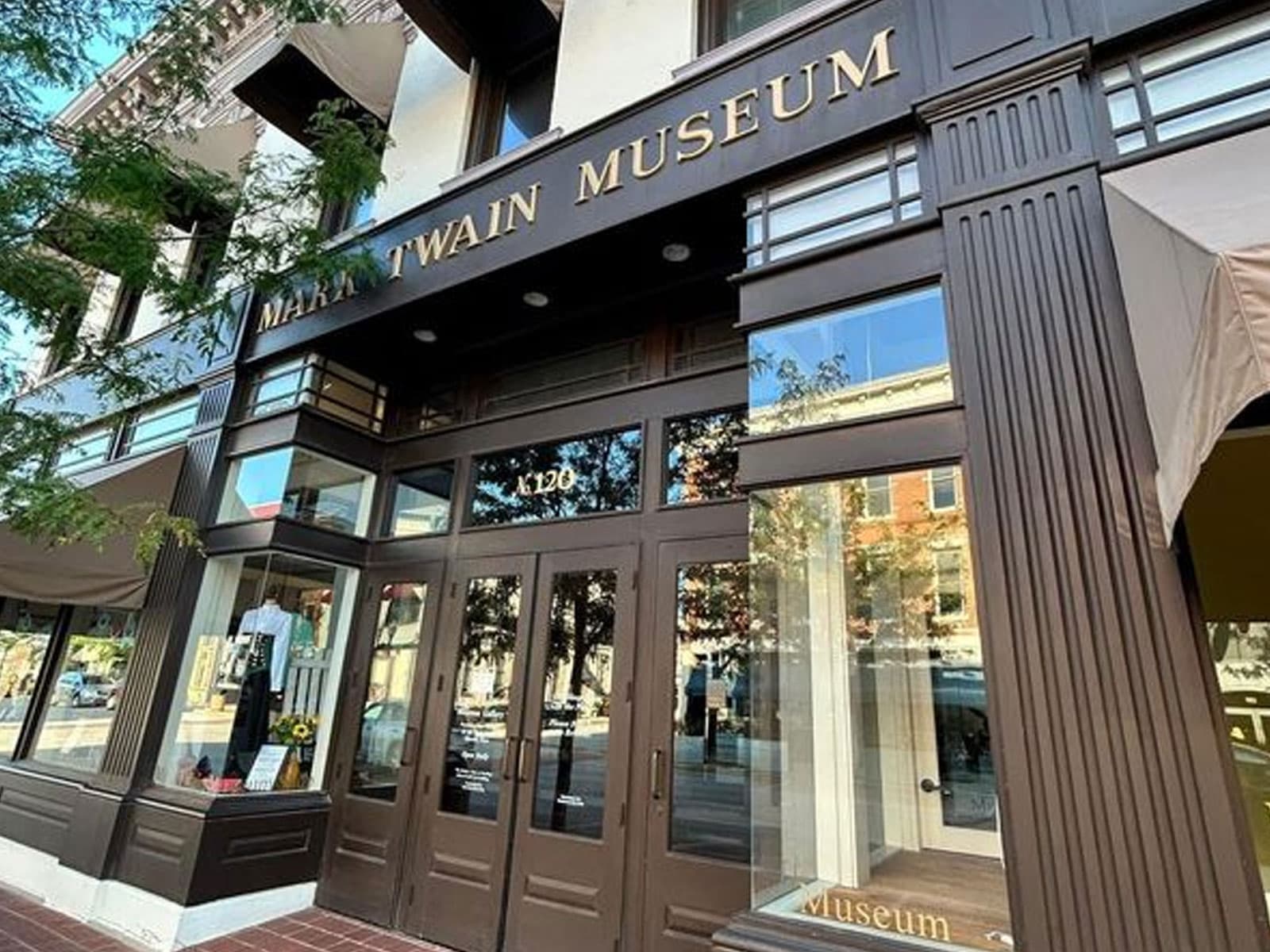 Exterior view of the Mark Twain Museum featuring large glass doors and signage.
