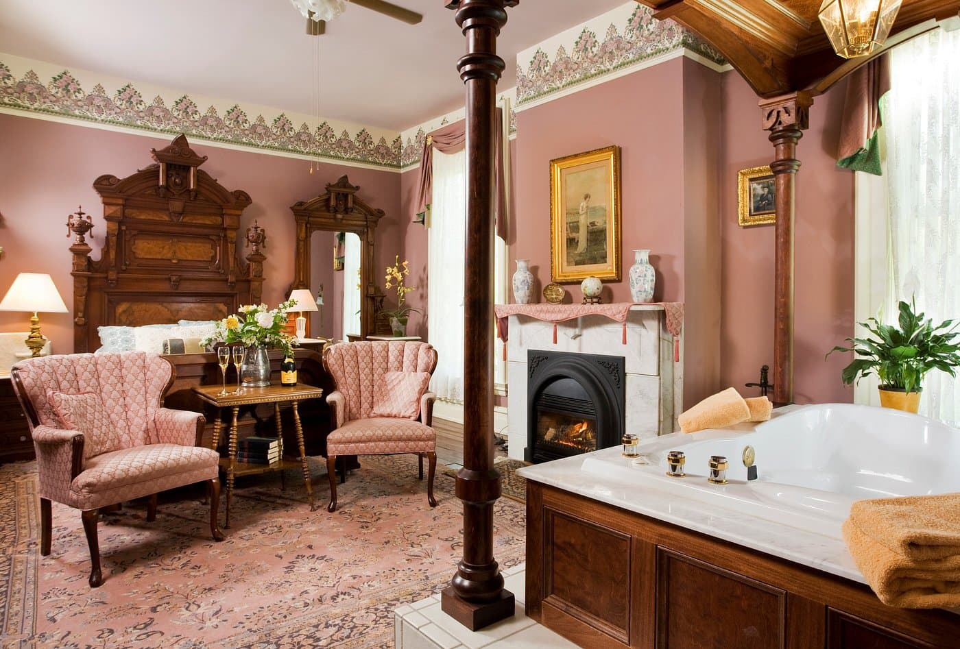 Luxurious bathroom with vintage decor, a soaking tub, and cozy seating.